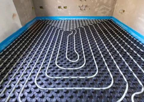 Vakkundig aangelegde buizen voor vloerverwarming, strak en gelijkmatig gemonteerd op noppenplaten voor optimale en zuinige warmteverdeling.