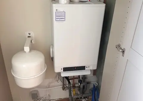 Ruimtebesparende installatie van een CV-ketel en wit expansievat, strak en veilig weggewerkt in een inbouwkast in Heiloo.
